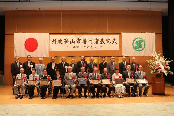 丹波篠山市善行者表彰式の受賞者が金屏風の前で、表彰状の入った額縁を持っての記念撮影
